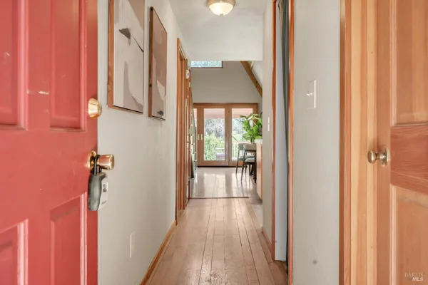 a view of a hallway with wooden floor and staircase