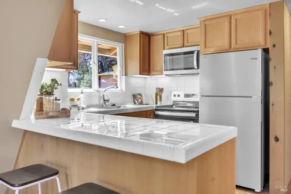 a kitchen with kitchen island a sink stove and refrigerator