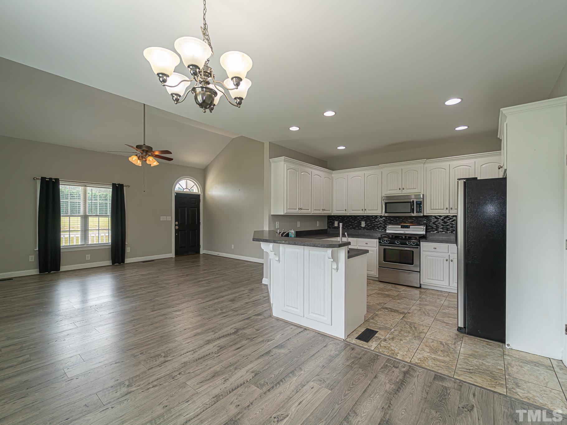 7730 La Finca Road Elm City, NC 27822 - Photo 8 of 29 a kitchen with a refrigerator and a stove top oven
