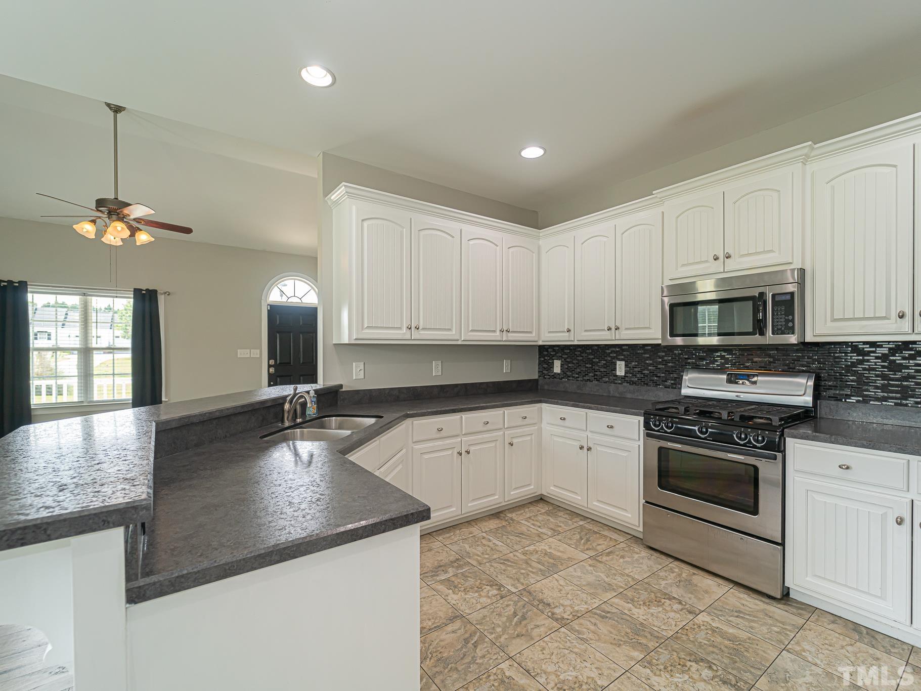 7730 La Finca Road Elm City, NC 27822 - Photo 9 of 29 a kitchen with stainless steel appliances granite countertop a sink a stove and oven