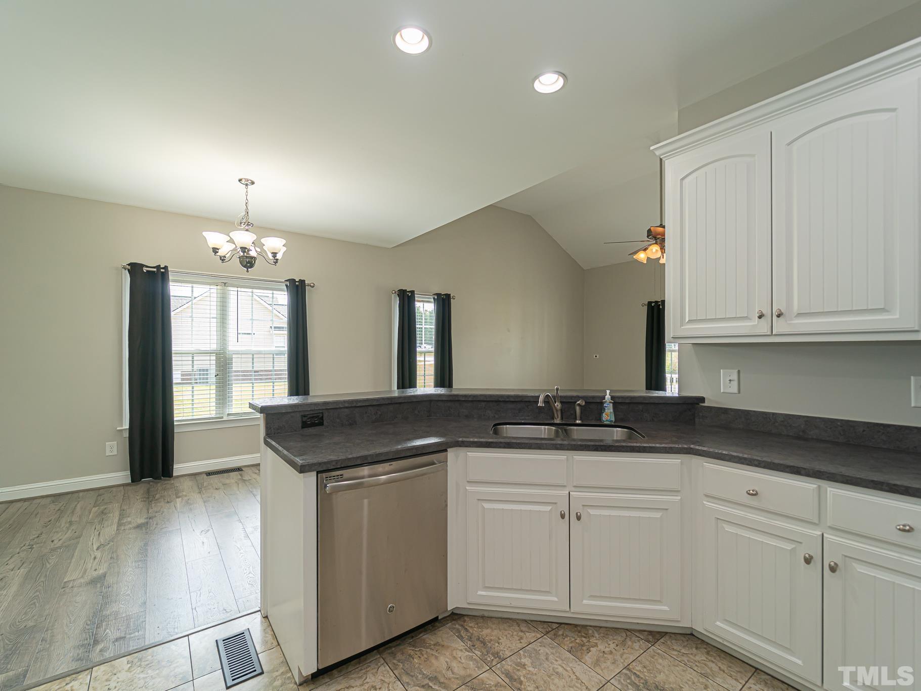 7730 La Finca Road Elm City, NC 27822 - Photo 10 of 29 a kitchen with granite countertop a sink and white cabinets