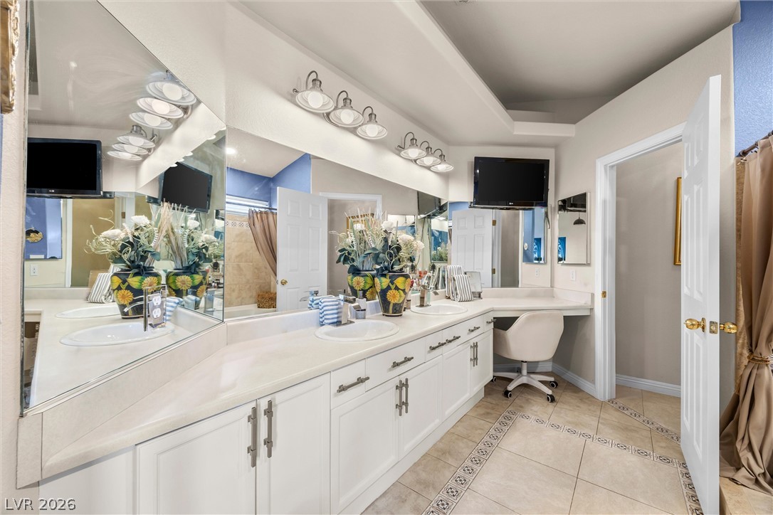814 Manor Shores Road Henderson, NV 89002 - Photo 20 of 40 An expansive vanity area with dual sinks, tiled flooring, and high ceilings leads into the bathroom.