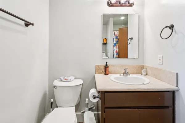 a bathroom with a sink vanity mirror and toilet