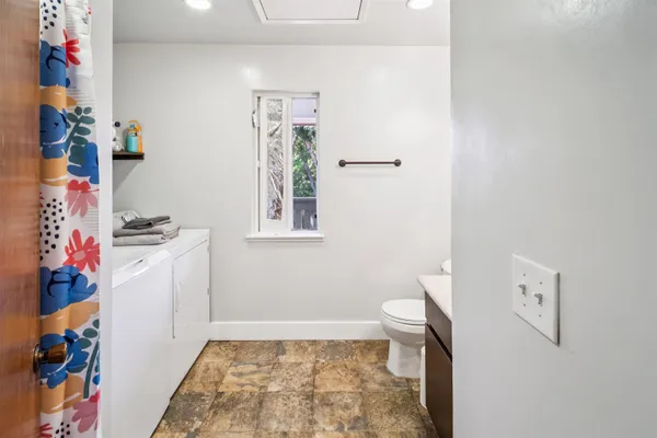 a bathroom with a sink a toilet and a shower curtain