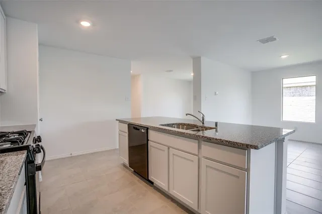 a kitchen with granite countertop a sink and a stove