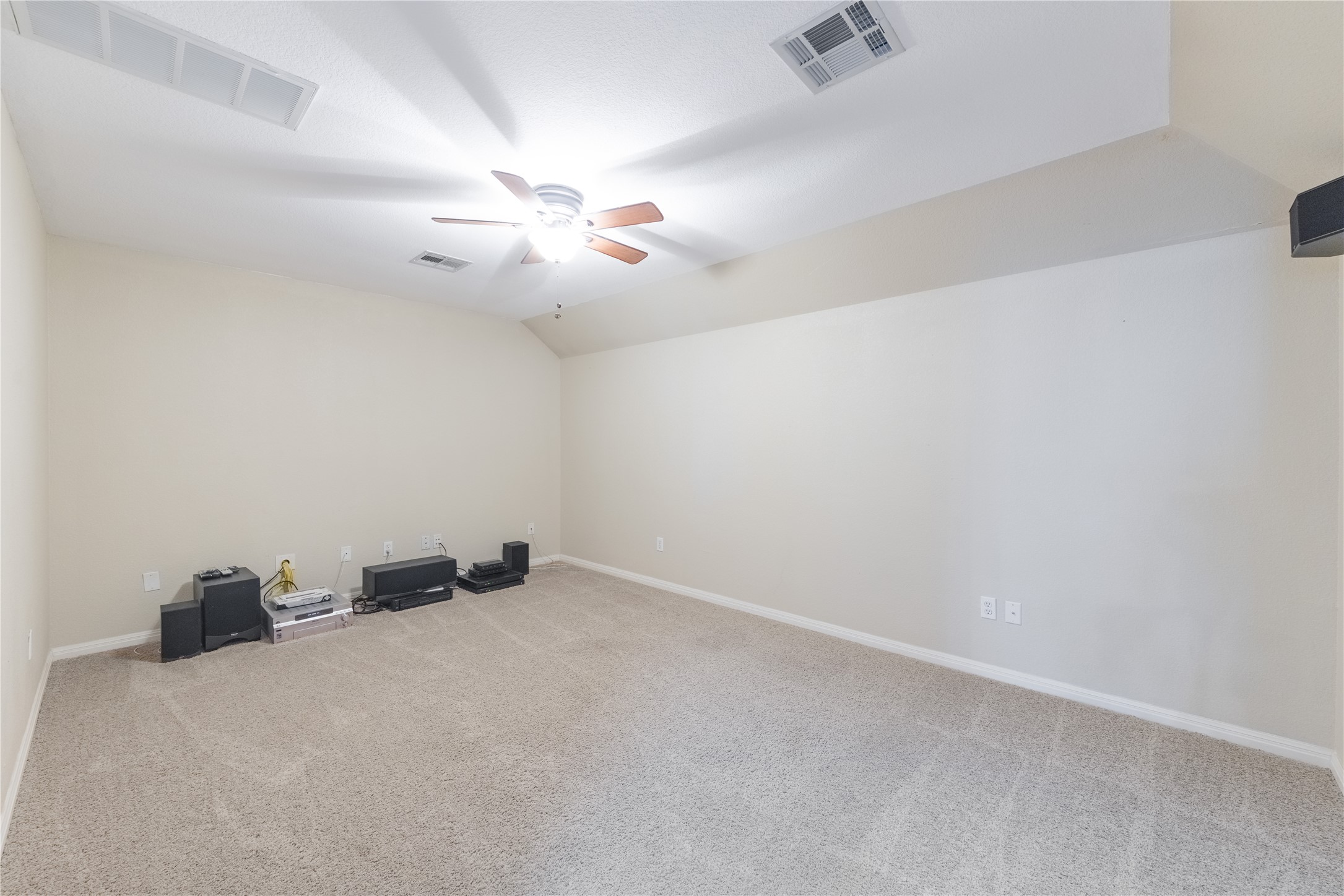 20145 Janak Road Coupland, TX 78615 - Photo 23 of 40 A spacious upstairs Media room offers comfortable carpet flooring and an elevated ceiling with a functional ceiling fan.