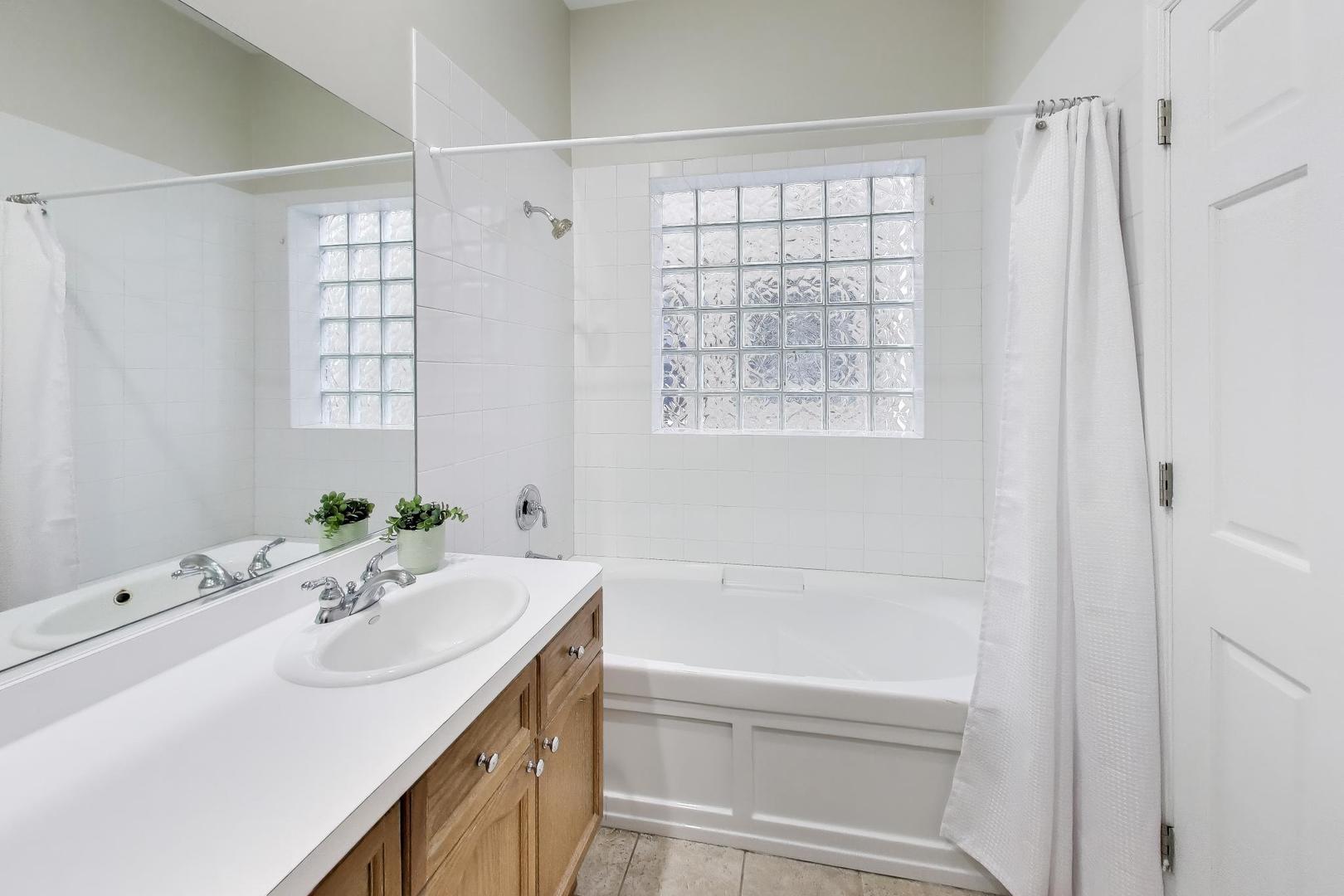 1312 West Fletcher Street, Unit 3W Chicago, IL 60657 - Photo 11 of 30 a bathroom with a sink tub vanity and a shower