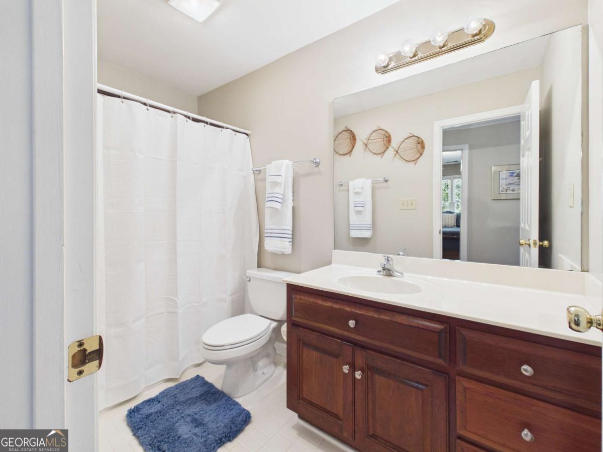 1120 Laurel Pointe Watkinsville, GA 30677 - Photo 29 of 50 a spacious bathroom with a granite countertop sink a toilet a mirror and shower curtain