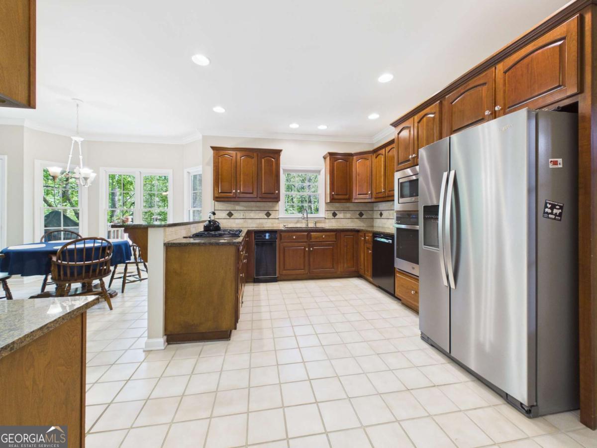 1120 Laurel Pointe Watkinsville, GA 30677 - Photo 7 of 50 a kitchen with stainless steel appliances a refrigerator a stove a sink a dining table and chairs