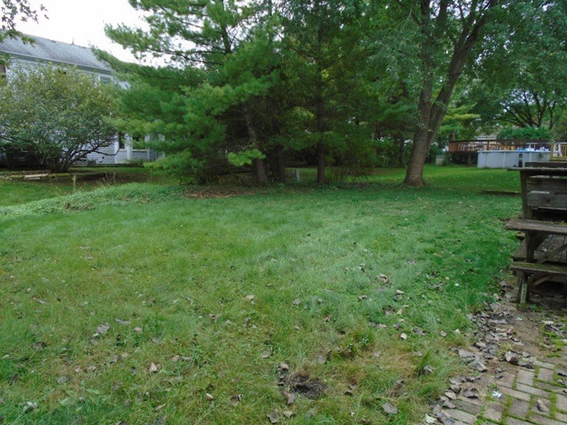 706 Hunters Way Fox River Grove, IL 60021 - Photo 11 of 17 a view of a backyard with table and chairs and potted plants and large trees