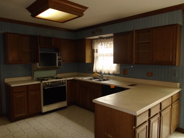 706 Hunters Way Fox River Grove, IL 60021 - Photo 9 of 17 a kitchen with stainless steel appliances granite countertop a stove a sink and a microwave