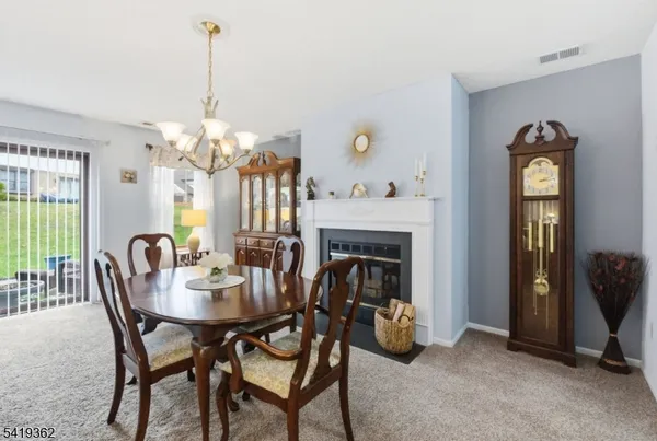 a view of a dining room with furniture and chandelier