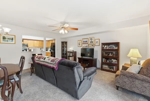 a living room with furniture ceiling fan and a window