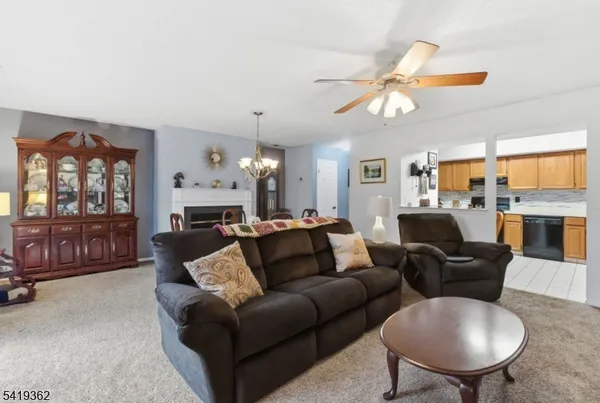 a living room with furniture a fireplace and a chandelier