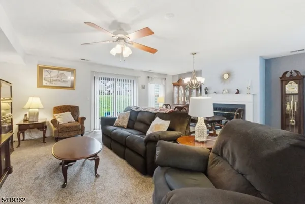a living room with furniture a fireplace and a chandelier
