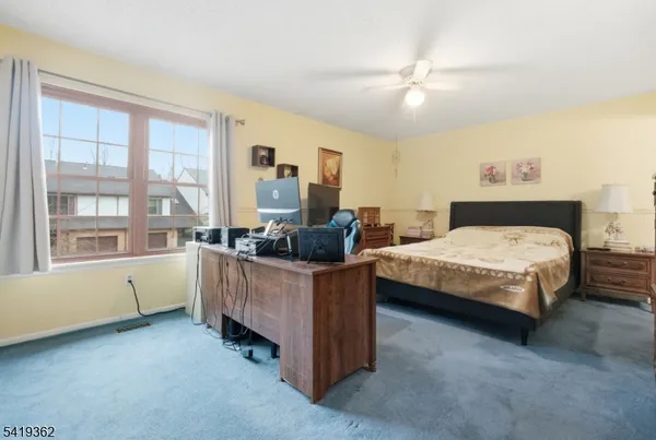 a bedroom with a bed dresser and a large window