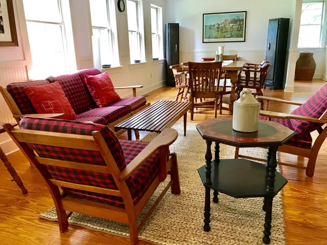 a living room with furniture a wooden floor and next to a window