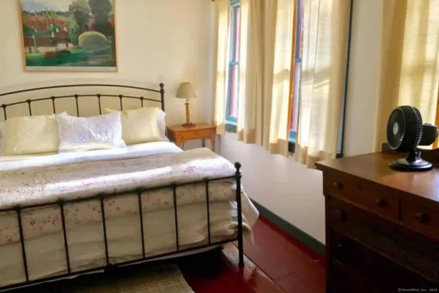 a bedroom with a bed window and a table in it