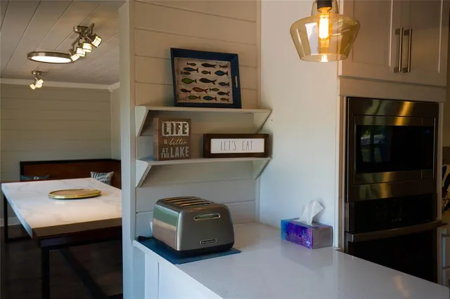 a kitchen with stainless steel appliances granite countertop a hardwood floor sink stove and granite counter top