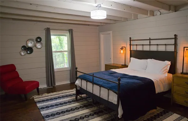 a bedroom with a bed and a mirror on the dresser