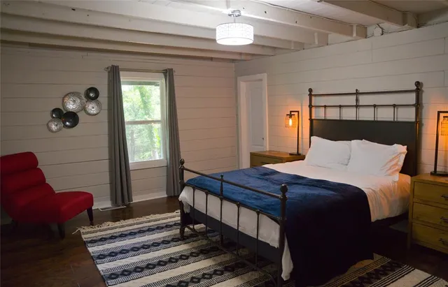 a bedroom with a bed and a mirror on the dresser