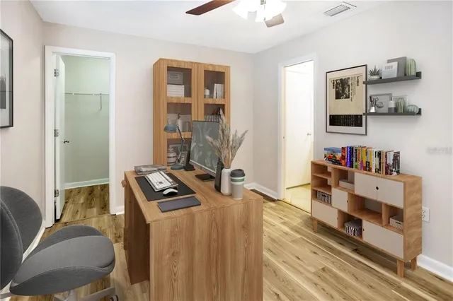wooden floor in an empty room with a chandelier fan