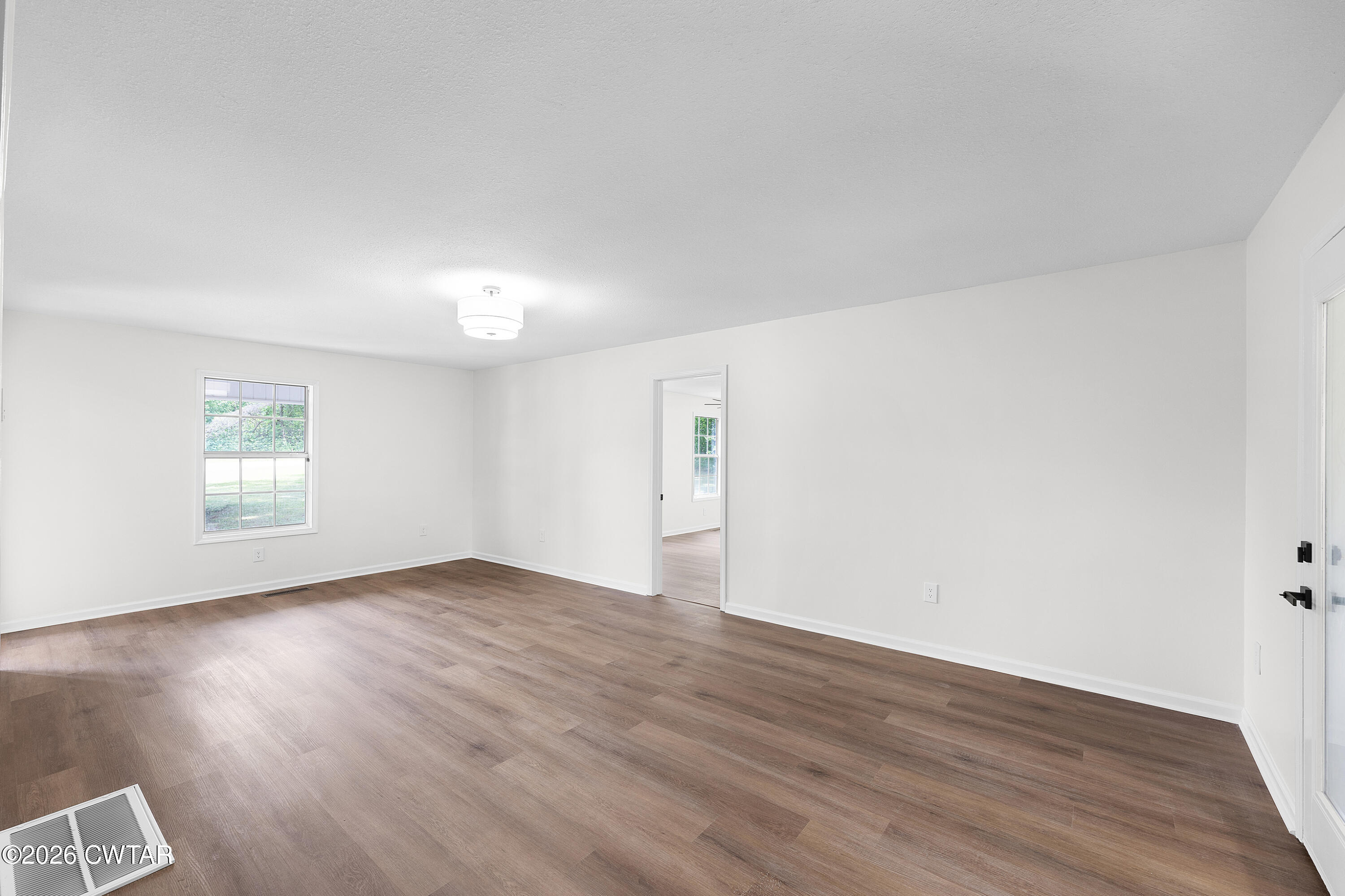 3075 Old Huntingdon Road Lexington, TN 38351 - Photo 3 of 19 an empty room with wooden floor and windows