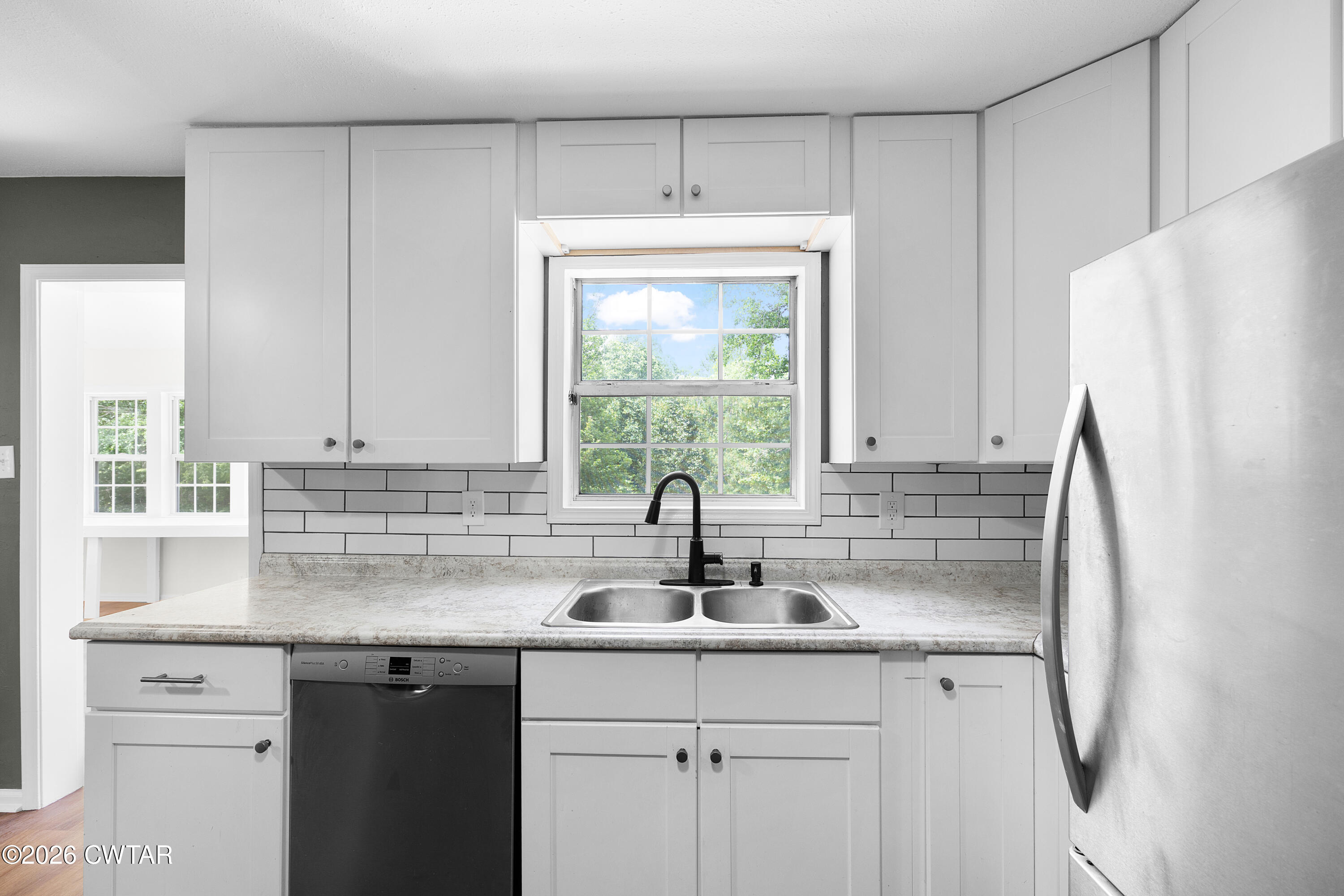 3075 Old Huntingdon Road Lexington, TN 38351 - Photo 6 of 19 a kitchen with stainless steel appliances white cabinets and a window