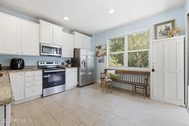 a kitchen with white cabinets and refrigerator
