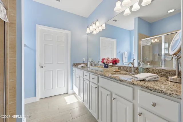 a bathroom with a double vanity sink and a mirror