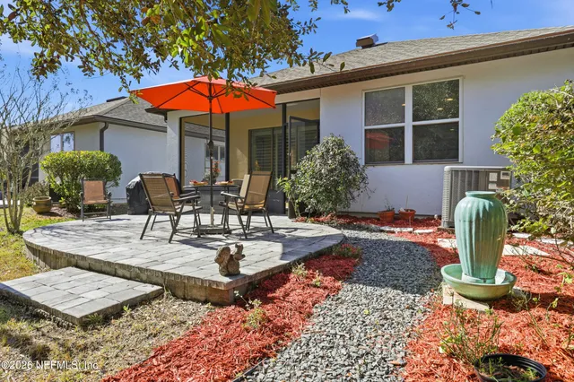 a view of a house with backyard and sitting area