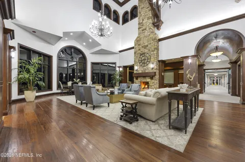 a living room with furniture a large window and wooden floor