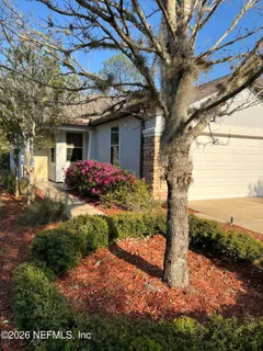 a front view of a house with a yard and potted plants