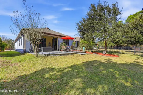 an aerial view of a house with swimming pool and red chairs