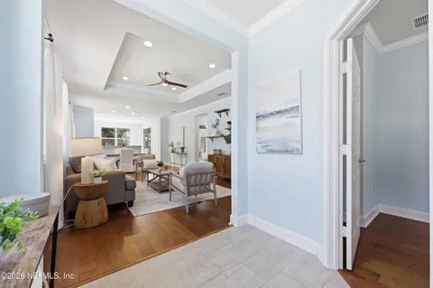 a living room with furniture a large window and wooden floor