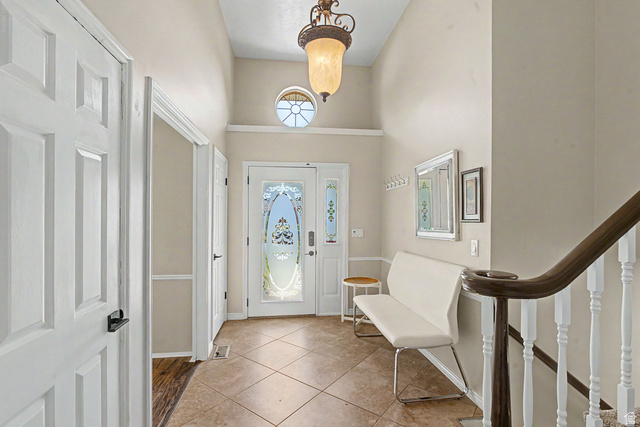Main Entryway with vaulted ceilings, glass front door and transom window, that adds to natural lighting.