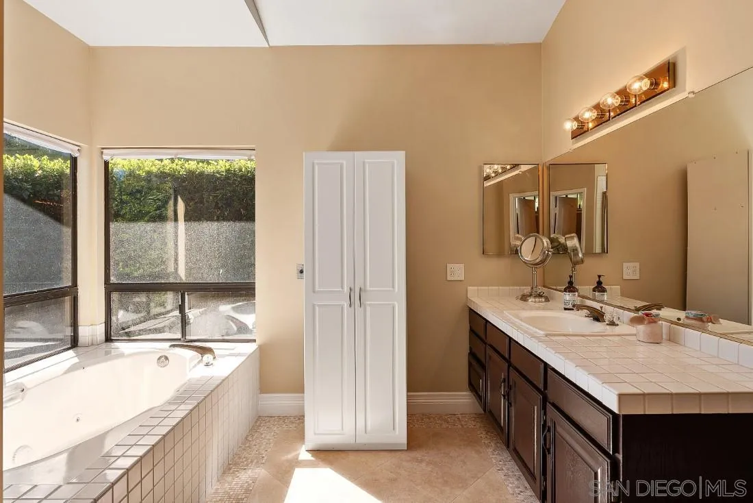 13862 Deergrass Court Poway, CA 92064 - Photo 26 of 51 a bathroom with a granite countertop tub sink and mirror