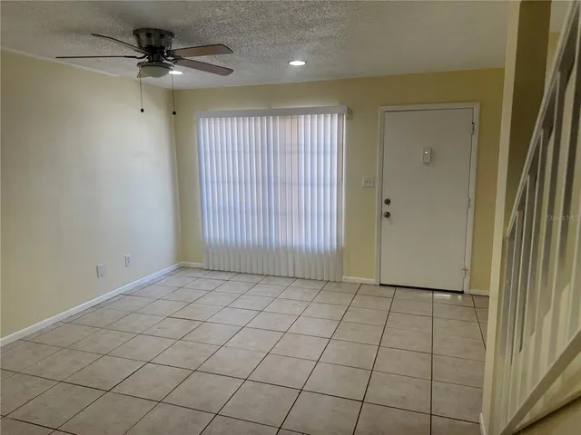 a view of a livingroom with a chandelier fan and windows