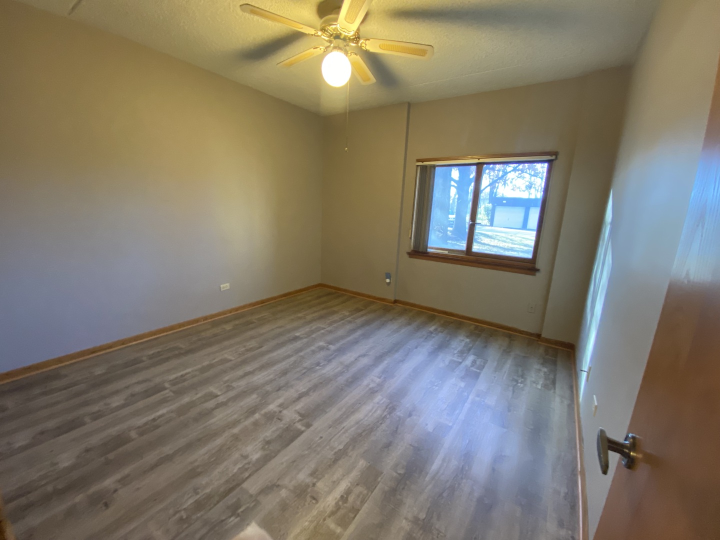 1105 East Division Street, Unit 1B Lockport, IL 60441 - Photo 13 of 22 a view of an empty room with wooden floor and a window