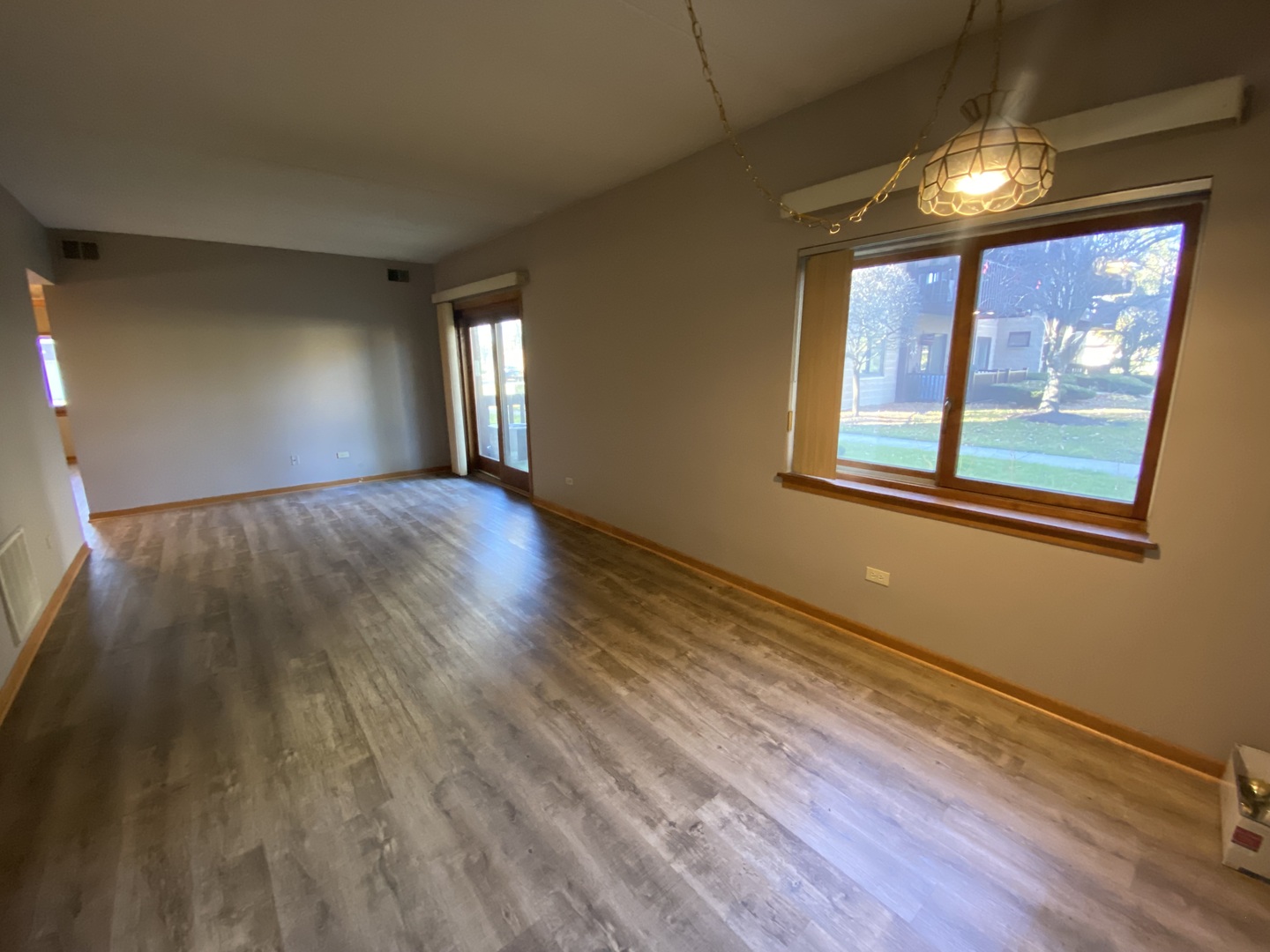 1105 East Division Street, Unit 1B Lockport, IL 60441 - Photo 8 of 22 a view of an empty room with wooden floor and a window