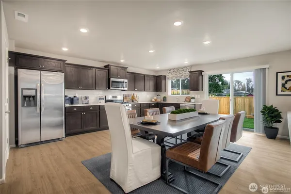 a dining room with furniture a large window and stainless steel appliances