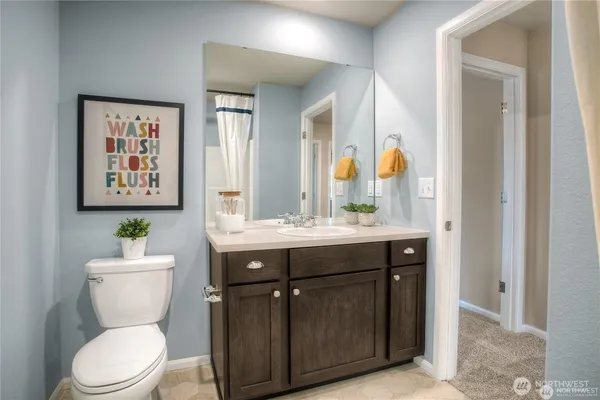 a bathroom with a toilet a sink and mirror