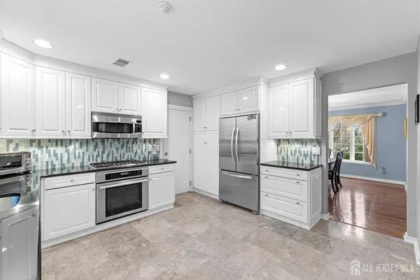 a kitchen with stainless steel appliances granite countertop a refrigerator and a stove top oven