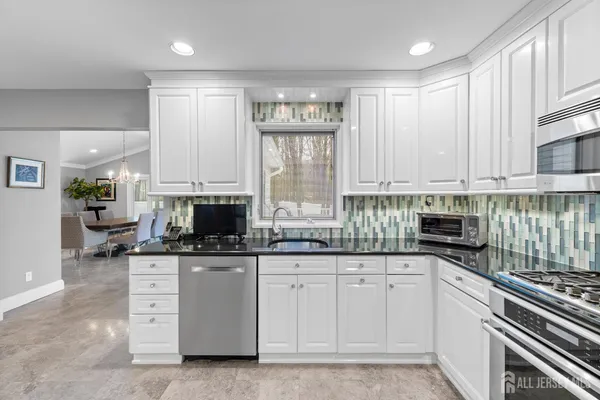 a kitchen with white cabinets and appliances