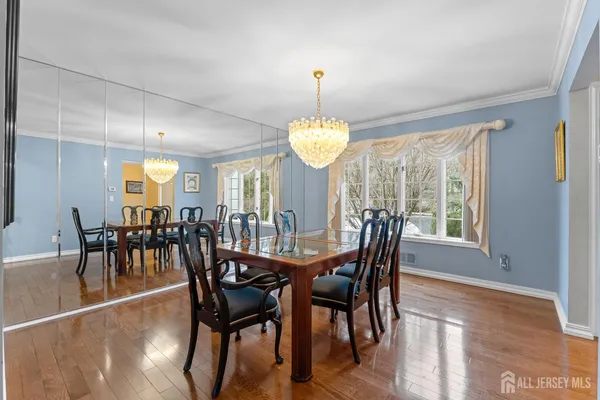 a dining room with furniture a chandelier and wooden floor
