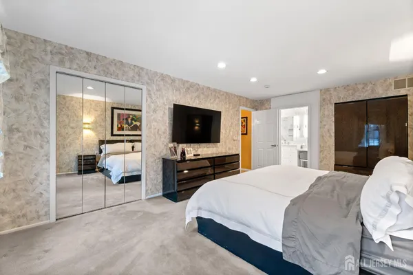 a bathroom with a sink a toilet a mirror and shower