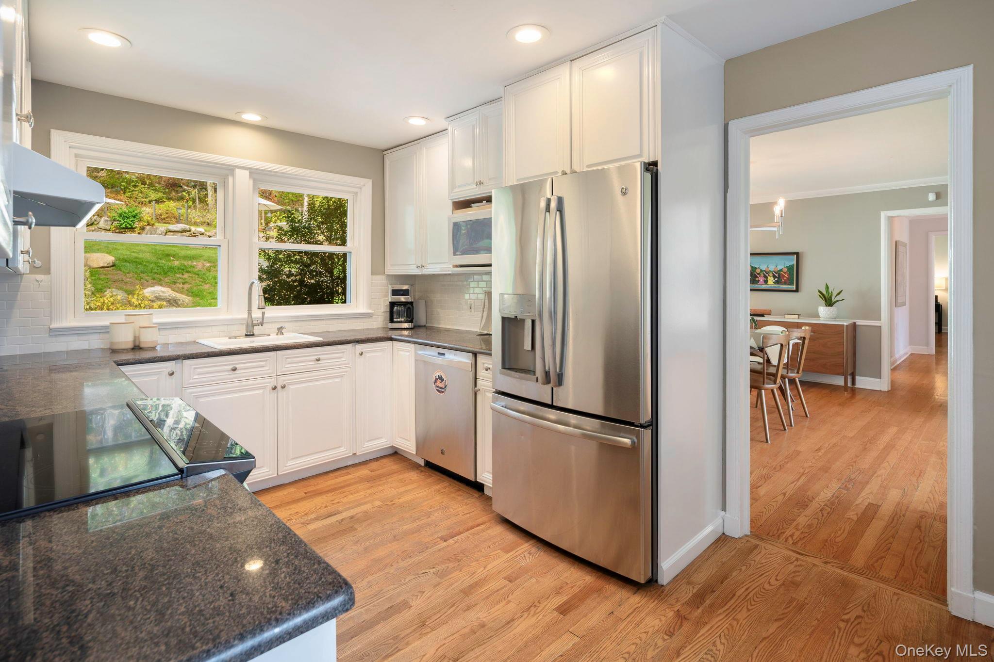 36 Pond Hill Road Chappaqua, NY 10514 - Photo 11 of 32 a kitchen with stainless steel appliances granite countertop a refrigerator a sink dishwasher a stove and white countertops with wooden floor