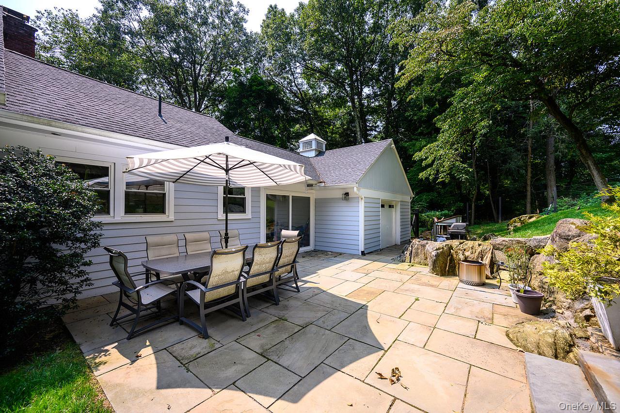 36 Pond Hill Road Chappaqua, NY 10514 - Photo 27 of 32 a view of a patio with table and chairs under an umbrella