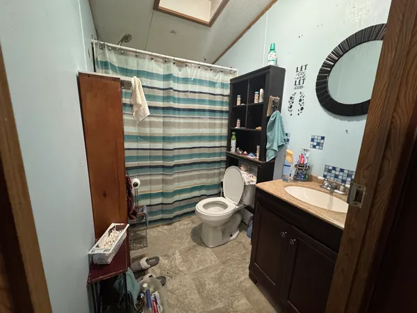 a bathroom with a toilet a sink and mirror