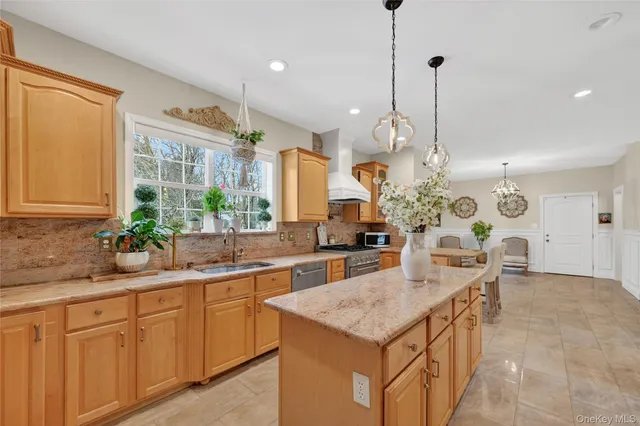 a kitchen with granite countertop a sink a stove and a wooden floors